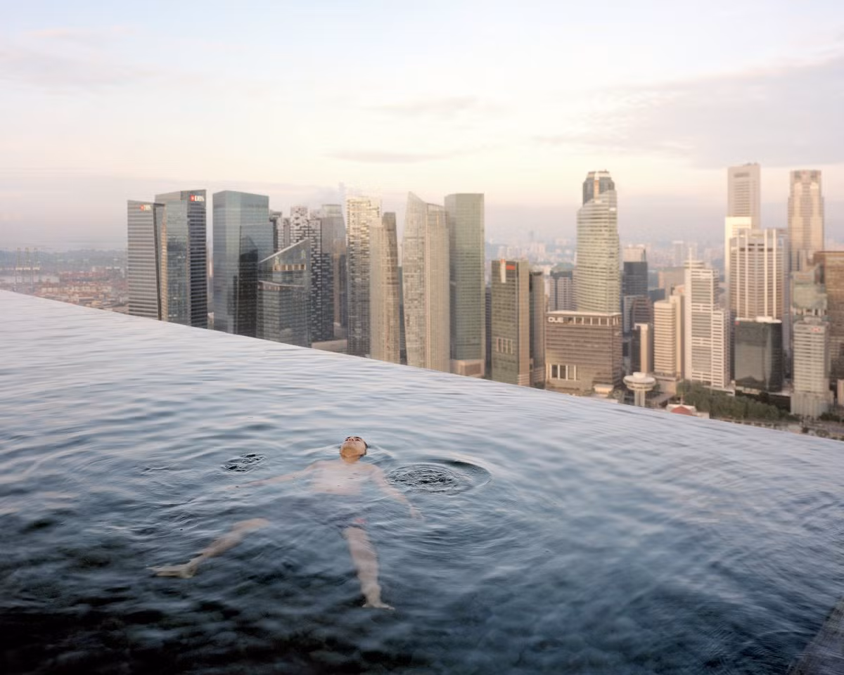 Người đàn ông đang thư giãn trong bể bơi vô cực trên tầng 57 của khách sạn Marina Bay Sands, Singapore.
