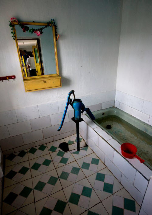 Để tới được ngôi làng Jung Pyong Ri, nhiếp ảnh gia Lafforgue kể phải mất nhiều giờ ngồi trên xe bus di chuyển qua những con đường lầy lội và đầy ổ gà dọc bờ biển phía đông Triều Tiên. Ông đã nhìn thấy hàng rào điện ven biển để ngăn chặn sự tấn công từ Nhật Bản. Chiếc máy bơm tay được lắp đặt trong phòng tắm. Nhiếp ảnh gia Eric Lafforgue cho biết ông đã bị điện giật khi sử dụng bình nước nóng ở đây.