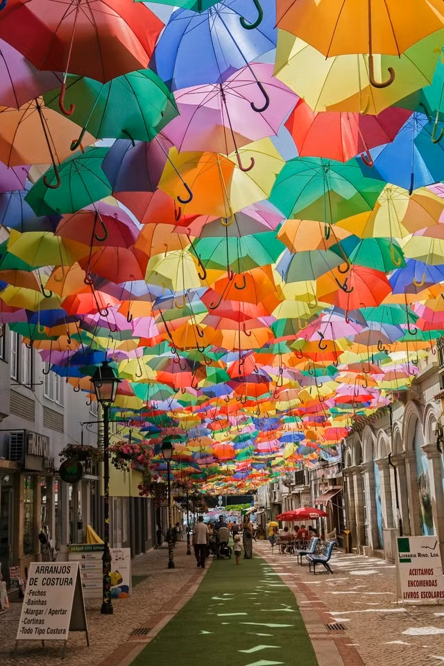 Agueda (Bồ Đào Nha): Vào tháng 7 hàng năm, các con phố ở Agueda lại ngập tràn dưới bóng mát của những chiếc ô đầy màu sắc được treo trên cao. Ảnh: Getty.