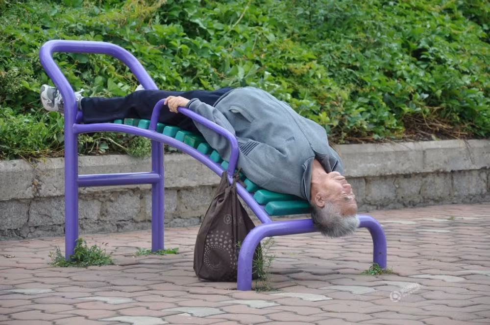 Cụ già ngủ ngay trên một dụng cụ thể dục ngoài đường. (Nguồn: QQ)