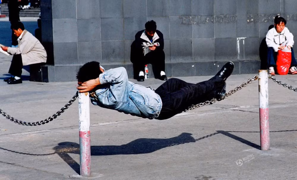 Có ai thắc mắc tại sao người này lại ngủ được trên dây xích ngoài đường thế này không? (Nguồn: QQ)