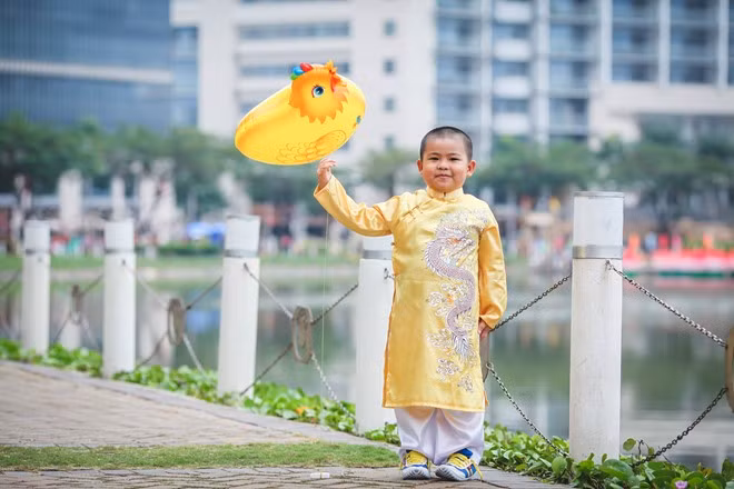 Nhiều trẻ em diện trang phục đẹp dạo chơi sớm. Em Khôi (4 tuổi) bị vuột tay, làm quả bóng chú gà bay mất sau khoảnh khắc này. Bé hồn nhiên hỏi ba: “Ba ơi, con gà biết bay hả ba?”