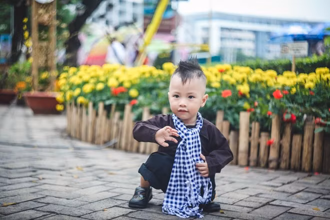 Sau khi theo ba mẹ chụp ảnh hơn 2 giờ đồng hồ, bé Nhật Minh (2 tuổi) mệt ngồi xuống và gọi ba mẹ.