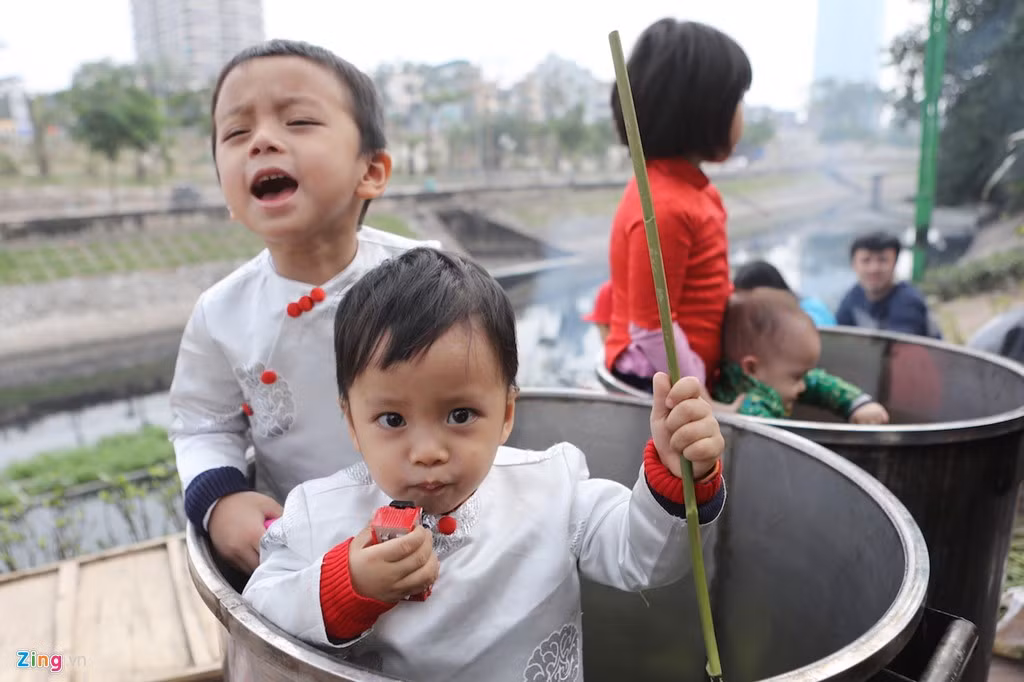 Trước khi người lớn chuẩn bị củi lửa luộc bánh, trẻ em được dịp chui vào thùng nghịch tạo nên một không khí Tết đến rất gần.