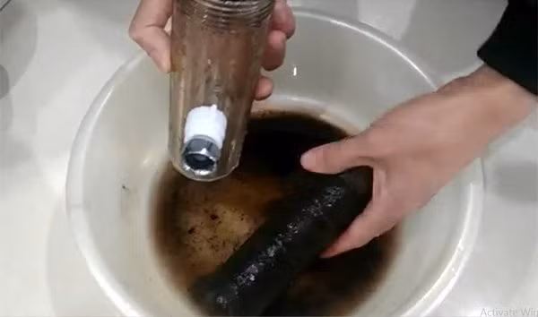 Lõi lọc nước đóng cặn bẩn đen sì sau 1 tuần sử dụng ở chung cư Meco Complex ngõ 102 Trường Chinh (Ảnh chụp màn hình: Trí thức trẻ)