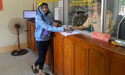 Chị Phạm Thị Hương mang phong bì tiền nhặt được vào nộp tại công an huyện Quế Phong (Nghệ An).