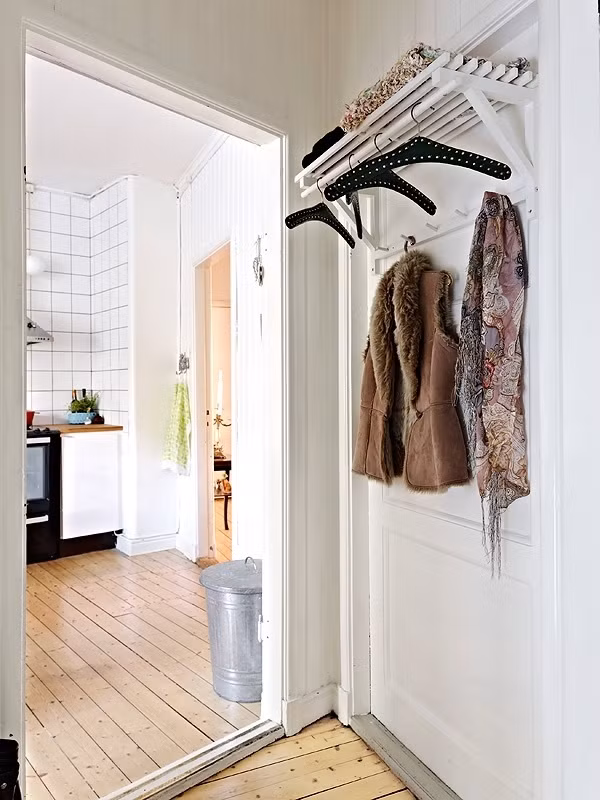 Lối vào nhà Chỉ với 58m2 nhưng vợ chồng gia chủ vẫn luôn thoải mái với đầy đủ các không gian chức năng cần thiết cho cuộc sống hàng ngày. Đầu tiên là khoảng nhỏ cho lối vào căn hộ nhỏ. Từ cửa chính bước vào là khoảng nghỉ với cách bố trí khá đơn giản nhưng cũng vô cùng hợp lý. Gia chủ đã khéo léo thiết kế móc treo và kệ phía trên móc giúp đồ đạc, phụ kiện được ngay ngắn, gọn gàng hơn.