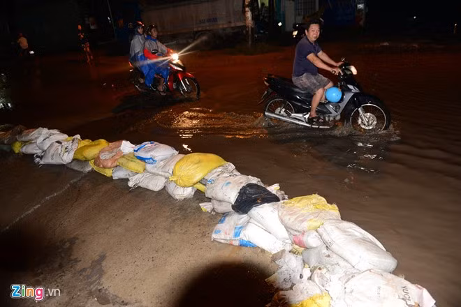Người dân dùng bao đất tấn ven đường ngăn không cho nước tràn vào nhà.