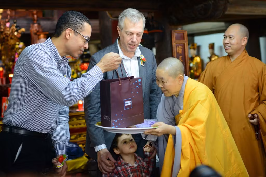 Ni trưởng Thích Đàm Thành tặng gia đình Đại sứ Osius món quà đặc biệt khác là chiếc bánh trung thu truyền thống của Việt Nam, điều làm gia đình đại sứ Mỹ rất thích thú.