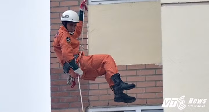 Cảnh sát phòng cháy đu dây tiếp cận mục tiêu.