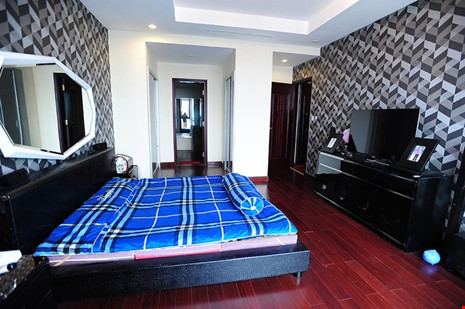 Phòng của bố mẹ được bổ sung những mảng tường họa tiết trầm ấm với nội thất gỗ màu đen sang trọng.