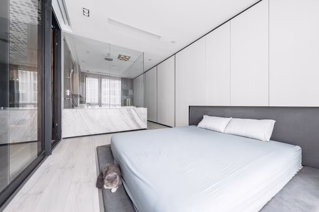 Phương châm sử dụng không gian mở được kiến trúc sư đưa lên hàng đầu khi nối thông phòng ngủ với công trình phụ chính. Toàn bộ phần tường gỗ trắng đối diện phòng tắm là tủ đồ âm tường.