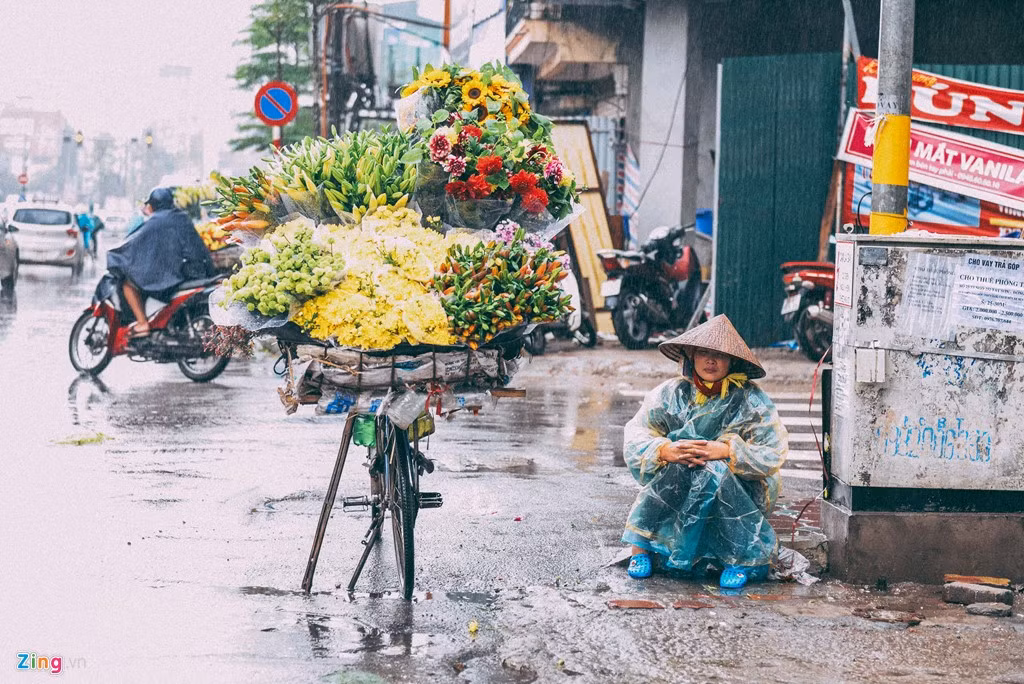 Ba ngày nay, không khí lạnh tăng cường khiến Bắc Bộ mưa rét, tuy nhiên nhiều người vẫn ra đường mưu sinh khi nhiệt độ giảm còn 15 độ C. Một người bán hoa dầm mình giữa mưa chờ người mua.