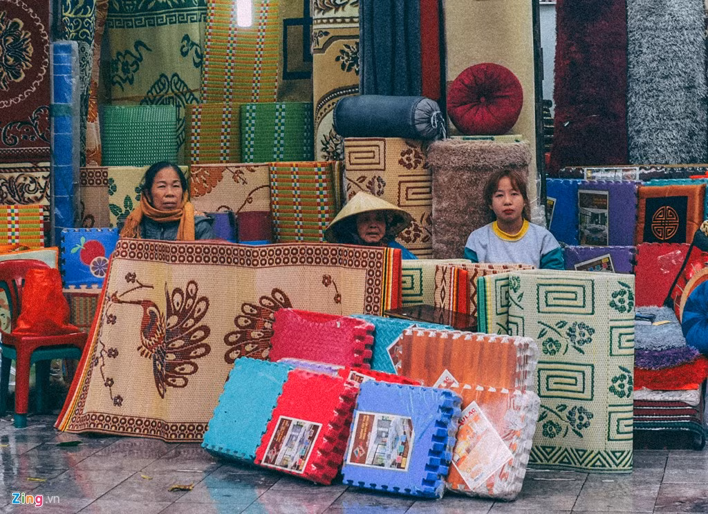 Những người bán hàng trên phố cổ quây chiếu quanh mình để tránh gió lùa.