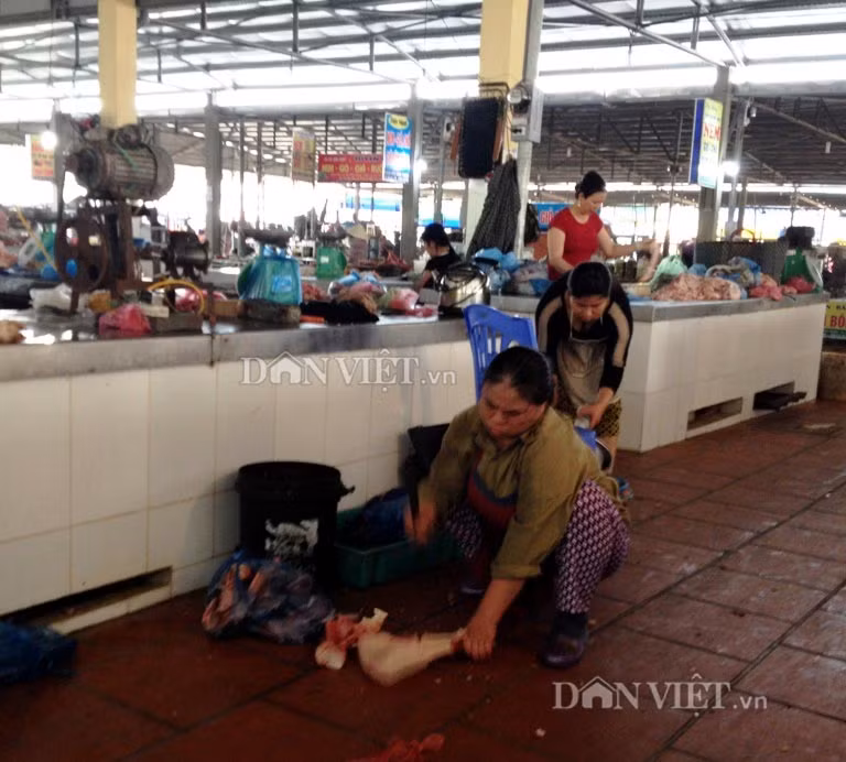 Người bán hàng “vô tư” chặt xương bò ngay dưới nền đất ướt nhầy nhụa.