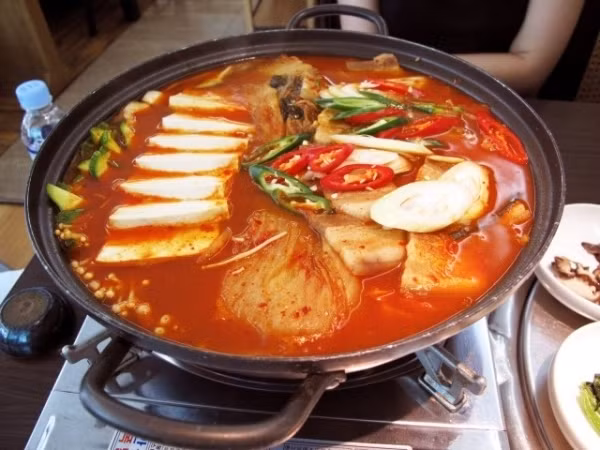 Lẩu kim chi Trong những ngày Hà Nội trải qua đợt rét kỷ lục này, một nồi lẩu kim chi cay xè sẽ là món ăn tuyệt vời nhất, giúp cơ thể ấm lên nhanh chóng. Lẩu kim chi khác với lẩu thông thường của Việt nam, nó có vị chua chua, cay cay của nước dùng được nấu từ kim chi cải thảo. Hơn nữa, mọi nguyên liệu trong món lẩu này đã được ninh chín từ trước, bạn không cần nhúng đồ sống vào nồi lẩu.