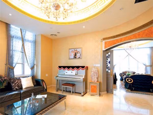 Với thiết kế mái vòm hình cung, sơn nhũ vàng kết hợp với chiếc đèn chùm lớn trong phòng khách đã tạo nên sự trang trọng, quyến rũ cho không gian.