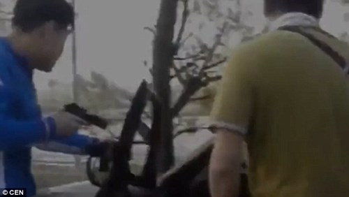 Cảnh sát mặc thường phục chĩa súng về phía chiếc xe chở hai nghi phạm bắt cóc và nạn nhân.