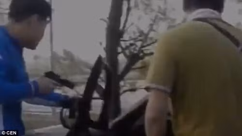 Cảnh sát mặc thường phục chĩa súng về phía chiếc xe chở hai nghi phạm bắt cóc và nạn nhân.