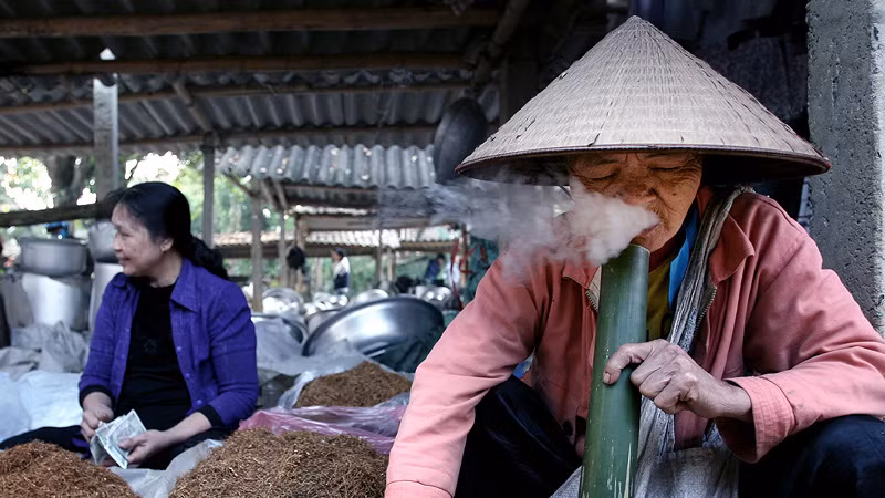 Cụ bà Bùi Thị Hới tận hưởng hương vị tuyệt thú của bi thuốc đầu tiên của ngày mới. Đã ngoài 80 tuổi, cụ Hới cho biết đã "khởi nghiệp hút thuốc" từ thời thiếu nữ.