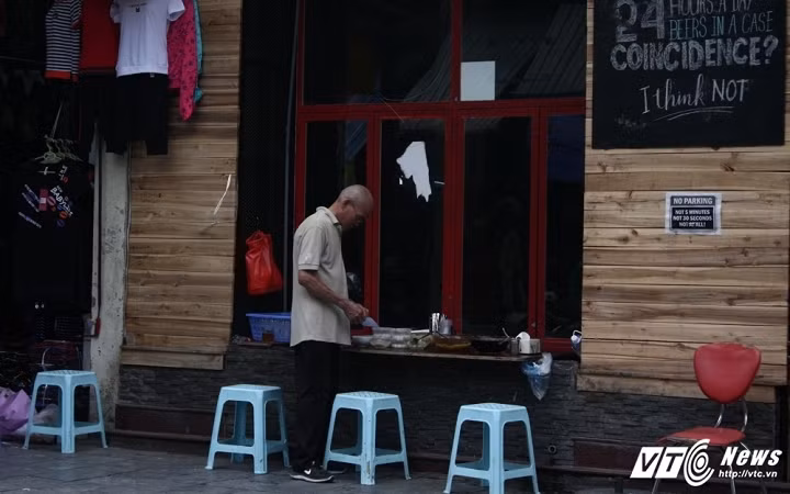Quán chè trên phố Hàng Đào (Hoàn Kiếm, Hà Nội) tận dụng khoảng không gian còn thừa từ cửa sổ của một tiệm quần áo. Cả quán chỉ có khoảng vài chiếc ghế cho khách ngồi ăn. Phần lớn người đến mua chè tại đây đều là mang đi. (Ảnh: Tùng Lâm)