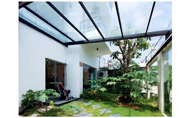 Sân vườn, nơi chủ nhân thường vui đùa với con trai. Hàng rào bằng kính tạo cảm giác khu vườn thật rộng rãi.