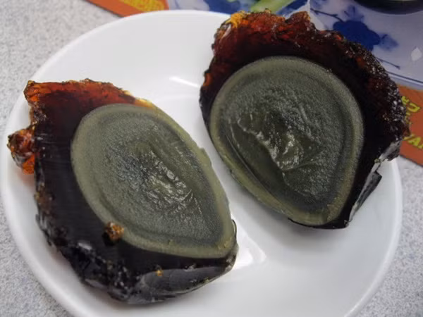 8. Trứng vịt bắc thảo Trứng vịt bắc thảo có màu đen hoặc nâu đen, xanh đen và tỏa ra thứ mùi khai khai, thum thum không dễ ngửi chút nào. Để chế biến món trứng này, người ta lựa những quả trứng vịt to, bọc với trà, chanh, đất sét, muối và tàn thuốc, sau đó cuộn tròn trong trấu để giữ chúng khỏi dính vào nhau và cứ ủ như vậy trong nhiều tuần, nhiều tháng thậm chí nhiều năm.