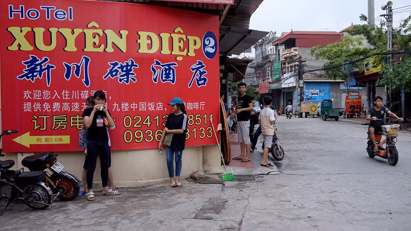 Biển hiệu quảng cáo một khách sạn gồm 3 ngôn ngữ, trong đó chỉ tên khách sạn viết bằng chữ Việt Nam.