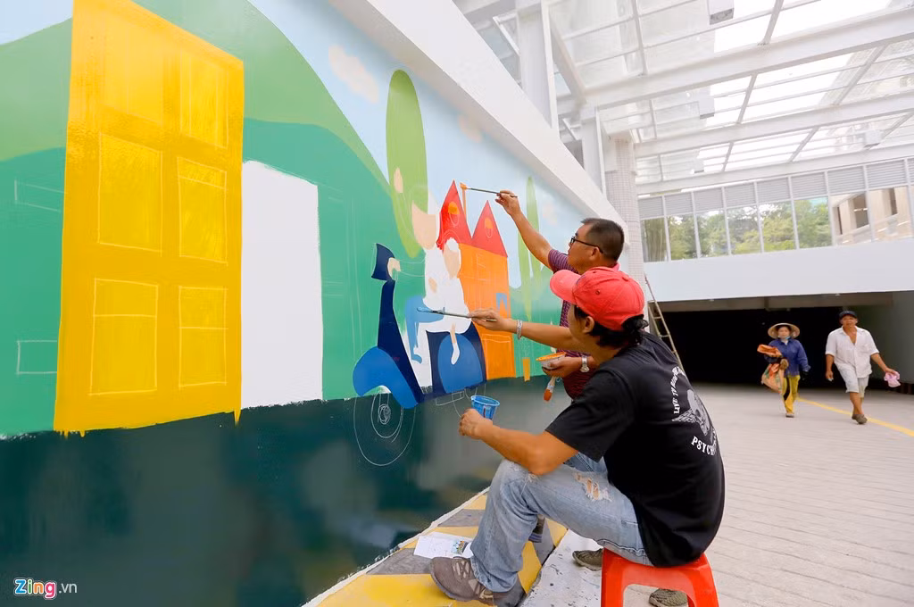 Nhóm họa sĩ vẽ những bức tranh nội dung về thiếu nhi lên bờ tường hầm xuống để xe của công trình.