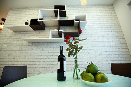 Một góc nhỏ khu bàn ăn. Một mảng tường được anh dán giấy giả tường gạch là điểm nhấn thú vị cho căn bếp độc thân lạnh lẽo.