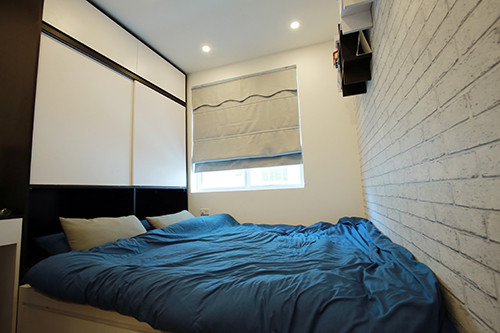 Phòng ngủ của anh Phương khá nhỏ, chỉ đủ chỗ kê giường và dành một góc để bàn làm việc. Tủ quần áo được thiết kế gắn sát trên tường để tiết kiệm diện tích.