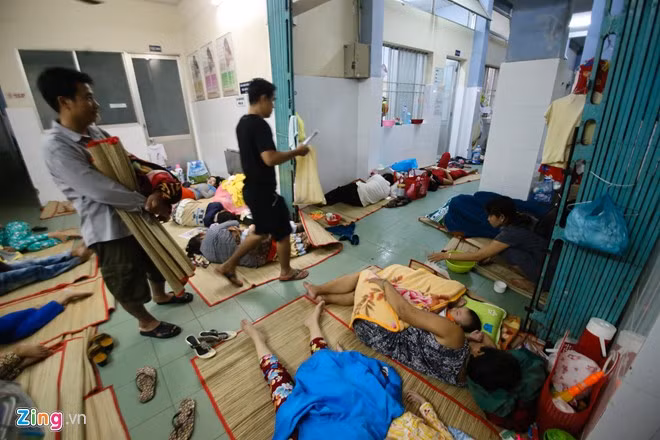 Một số nơi bị dột, người nhà bệnh nhân bị đánh thức vác chiếu qua vị trí khác để tìm chỗ ngủ.