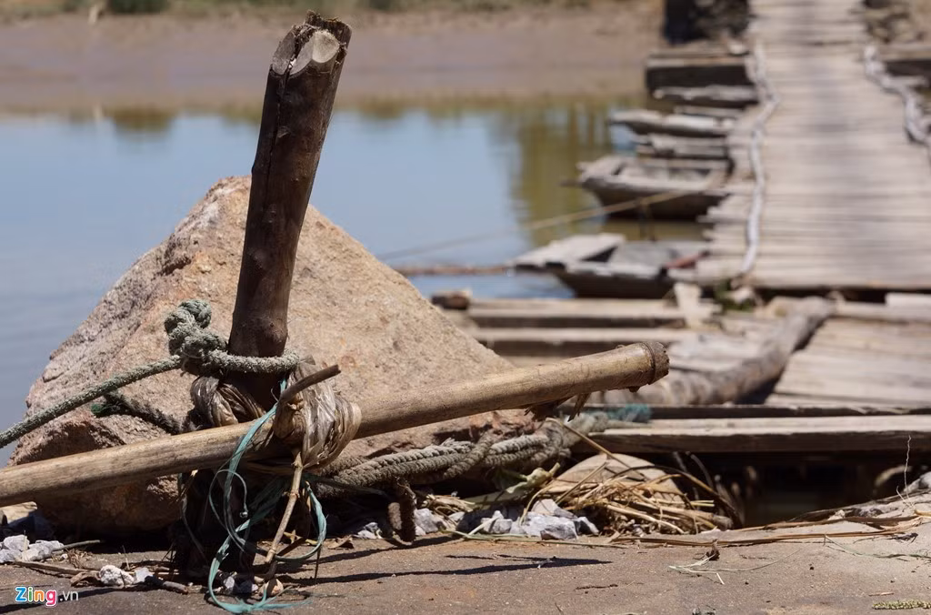 Điểm kết nối hai đầu cầu với bờ sông được buộc bằng dây thừng với các cọc tre tạm bợ.