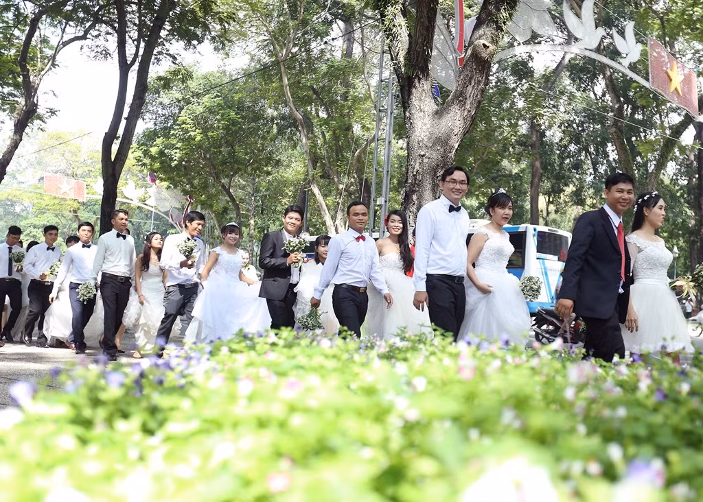 Nhân dịp triển lãm cưới chuẩn bị khai mạc tại TP HCM, các đôi cô dâu, chú rể chia làm nhiều tốp, có buổi chụp ảnh cưới tập thể với những thắng cảnh nổi tiếng ở Sài Gòn sáng 6/8.