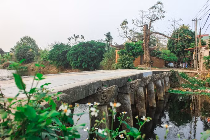 Ghé thăm chùa Nôm, du khách phải đi qua cầu đá. Cây cầu đá bắc qua bờ sông Nguyệt Đức đã tồn tại trên 200 năm. Cầu được làm hoàn toàn bằng đá xanh với nhiều nét chạm đục công phu. Cây cầu đá gồm 9 nhịp đầu rồng đã mấy trăm năm nay soi bóng xuống dòng sông Nguyệt Đức, nâng bước các phật tử đến chùa.