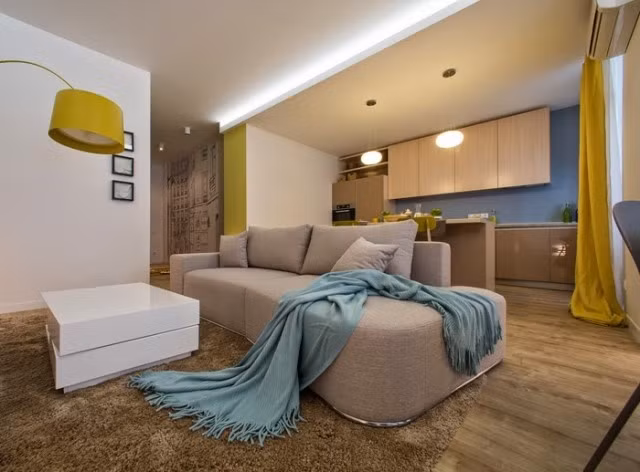 Thảm trải sàn màu nâu đất vừa giúp không gian có cảm giác thân thiện vừa làm nền cho bàn trà và kệ để ti vi thêm nổi bật trong không gian sinh hoạt chung của gia đình.