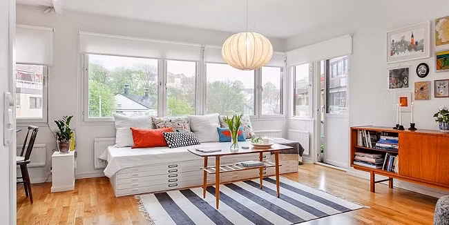 Không gian tiếp khách Từ cửa chính bước vào nhà là không gian phòng khách với nhiều chức năng phụ giúp căn phòng trở thành 'điểm đến' và cũng là 'điểm dừng' yêu thích của tất cả các thành viên trong gia đình. Để tạo nên cảm giác rộng rãi cho căn phòng này, gia chủ đã chọn trắng làm tông màu nền cho toàn bộ không gian.