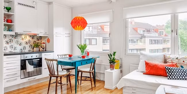 Không gian ăn uống Không gian tiếp khách được nối liền với không gian ăn uống, chỉ phân tách bằng một chiếc kệ thấp nho nhỏ giúp không gian bớt đi sự chật chội thường thấy ở những căn hộ nhỏ. Bộ bàn ăn được gia chủ chọn mua với kiểu dáng cổ điển. Màu sắc của bộ bàn ăn lại được chọn những gam màu khá hiện đại và hút mắt. Sự kết hợp nhẹ nhàng này mang đến khá nhiều cảm giác thú vị cho không gian ăn uống.