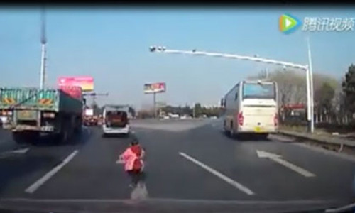 Cháu bé bị rơi từ phía sau xe ô tô đang cố gắng chạy theo chiếc xe của ông.(Ảnh từ clip)