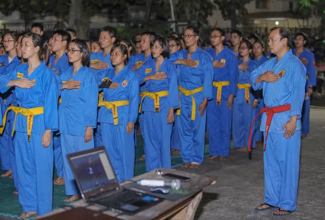 Phát ngôn viên Bộ Ngoại giao sinh năm 1977, bắt đầu theo nghiệp võ từ năm 12 tuổi. Trước khi gắn bó với Vovinam, ông đã trải qua một số môn phái khác. Trong ảnh, những huấn luyện viên (đai vàng) làm lễ chào cờ.