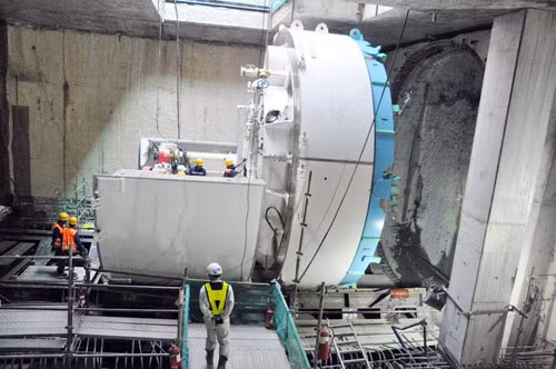 Robot TBM sẽ đào đường hầm dài 781m để kết nối với đoạn đang thi công đào hở ở hai đầu nhà ga. Hầm gồm 2 ống hầm đơn dài khoảng 318m và 2 ống hầm song song dài 463m. Đường kính ngoài vỏ hầm 6,65m, đường kính trong 6,05m.