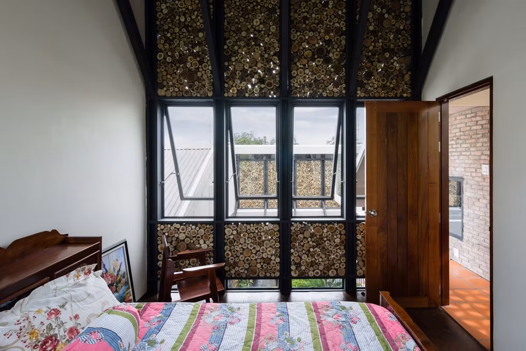 Phòng ngủ tầng 2 với tường và cửa sổ trang trí bằng miếng gỗ.