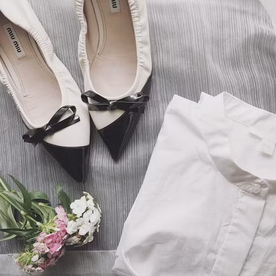 Giày Miu Miu màu trắng đen rất hợp để cô mix với áo sơ mi trắng tinh khôi.