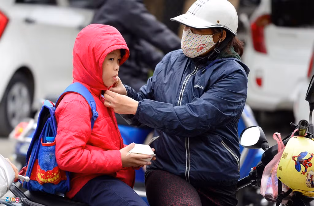 Sau hơn một tuần ấm áp, nhiều em nhỏ chưa kịp thích nghi với gió lạnh. Một số học sinh vẫn còn không chịu mặc áo khoác hoặc mặc nhưng không kéo kín cổ khiến phụ huynh phải chỉnh sửa cho con.