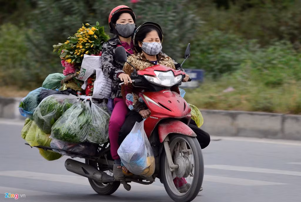 Từ sáng sớm, những người đi xe máy ngoài đường có thể cảm nhận rõ cái lạnh cắt da cắt thịt. Hình ảnh tại cửa ngõ thành phố trên địa bàn quận Thanh Xuân, người buôn bán trang bị áo ấm chở hàng tới chợ.