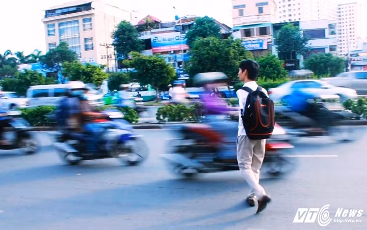 Chàng trai không tay băng qua đường để đón xe buýt.