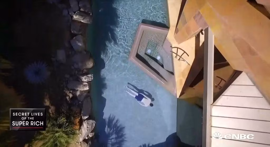 Khung cảnh bể bơi nhìn từ trên xuống. Bể bơi này bao quanh ngôi nhà và được ngăn các phần bằng vách kính lửng.