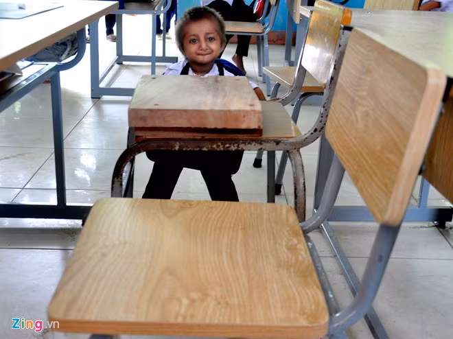 Do học sinh này chỉ cao 55 cm, lãnh đạo nhà trường đặt thợ mộc đóng thêm lớp gỗ dày tạo "chiếc ghế đặc biệt" để cậu bé ngồi học thuận lợi.