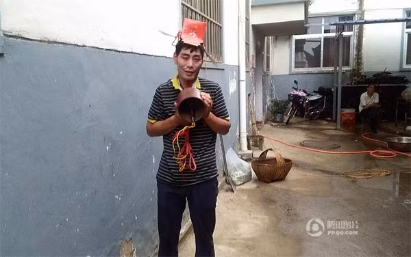 Trước khi bị treo lên cột điện, chú rể còn bị bắt buộc phải đội mũ giấy lên đầu và đeo chuông nặng hơn 10kg vào cổ.