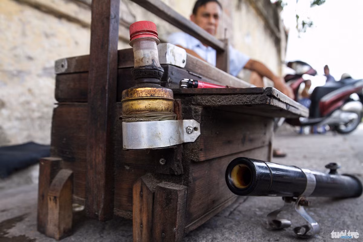 Chiếc hòm như này có tuổi đời lên tới gần 30 năm. Nó được làm bằng gỗ có hai tầng, là vật để đựng những cốc, chén, những bao thuốc là, bật lửa đã trở thành “kỷ vật” đặc biệt gắn liền với những người bán nước trà bên nhà máy dệt hay những người bán trà trên tàu lửa - Ảnh: NAM TRẦN